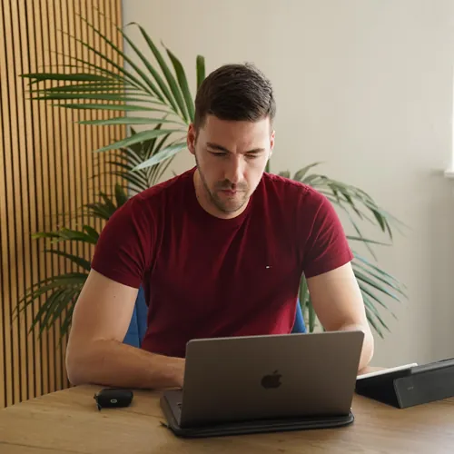 Versicherungsmakler Rick sitzend am Laptop